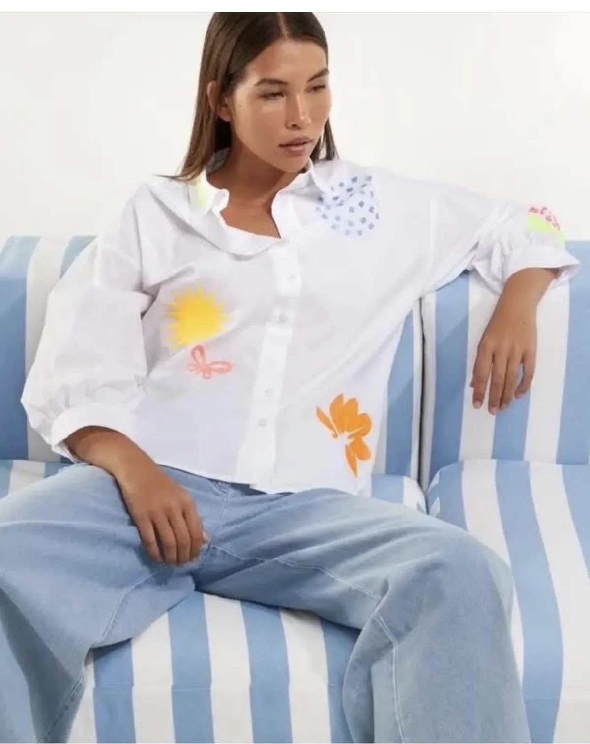 Dames witte oversized blouse met handgeschilderde print en lichtblauwe jeans